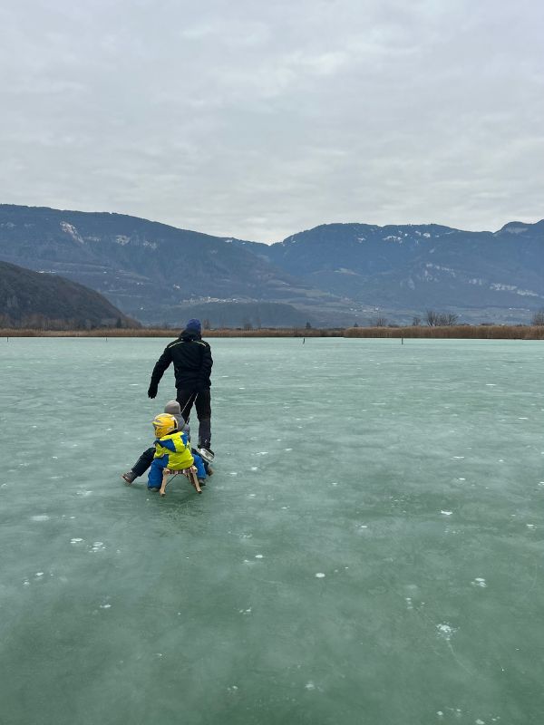 Eislaufen auf dem Kalterer See in Südtirol im Winter