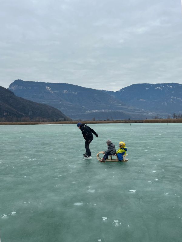 Eislaufen auf dem Kalterer See in Südtirol im Winter