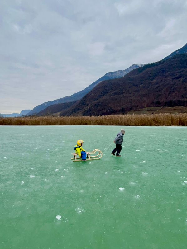 Eislaufen auf dem Kalterer See in Südtirol im Winter